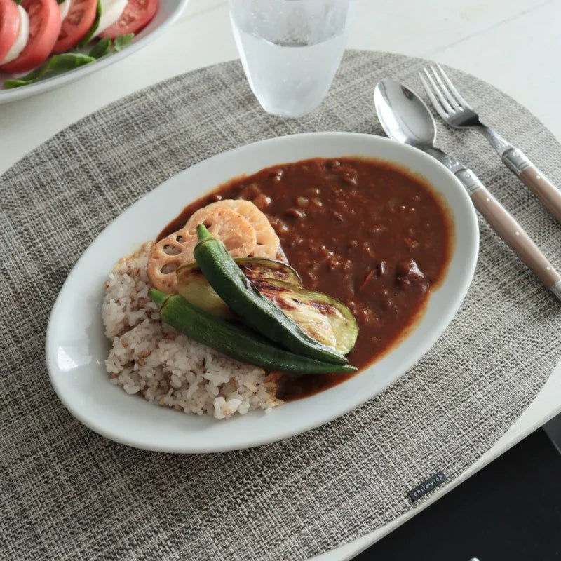 サタルニア チボリ オーバルプレート28cmにカレーとごはん、野菜を盛り付けた食卓