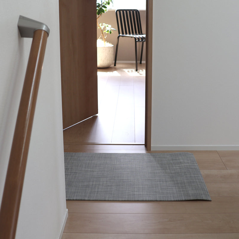 木目フローリングの玄関に置かれたチルウィッチ 玄関マット Woven イカット 59×92cm White/Silver