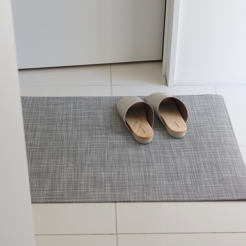 白いタイルの玄関に敷いたチルウィッチ 玄関マット Woven イカット 59×92cm White/Silverとスリッパ