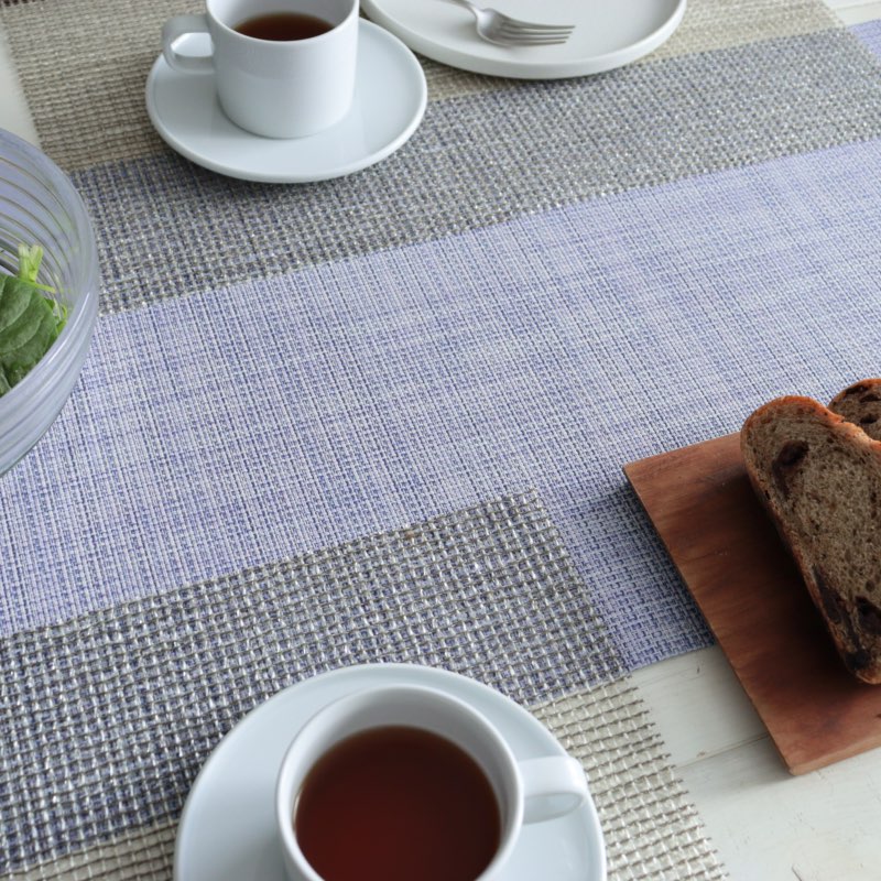 「Chilewich Mini Basketweave ランナー（ペリウィンクル）」を使用したテーブルセッティング。コーヒーとチョコレートブレッドが並ぶシンプルで落ち着いた食卓。